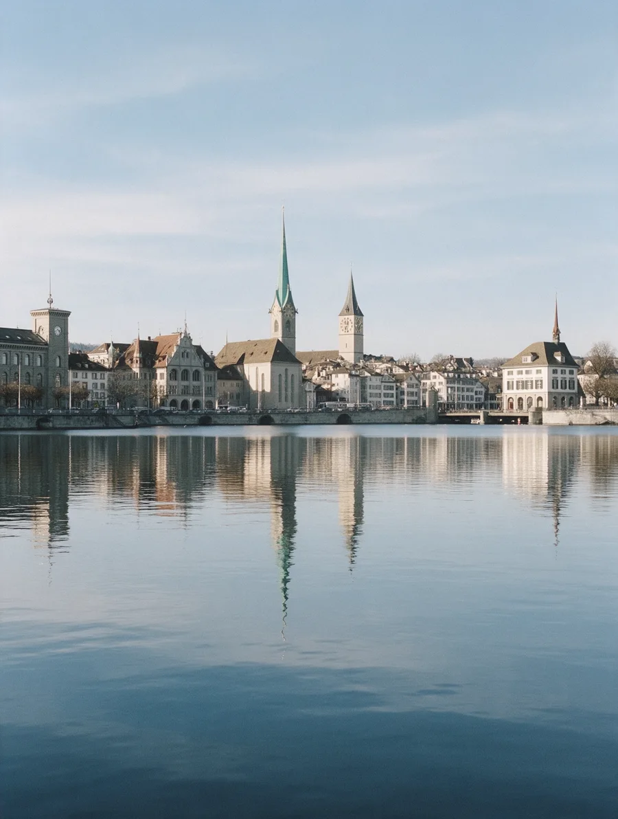 Zurich church towers reflected in the river by day.