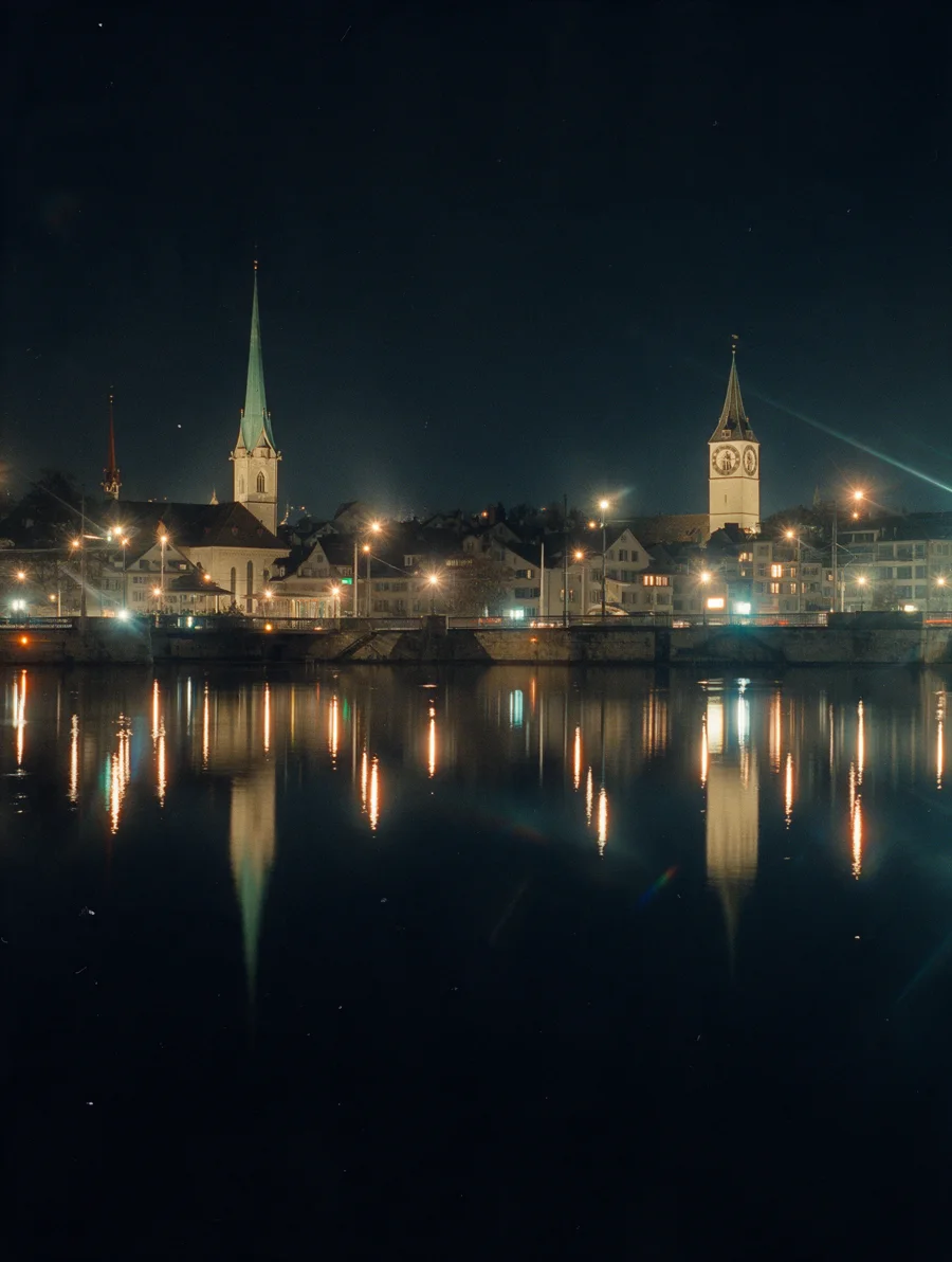 Zurich church towers reflected in the river at night.